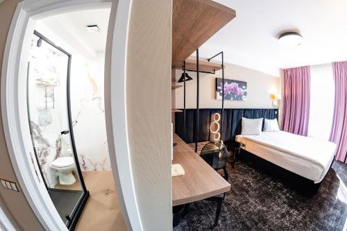a hotel room with a bed and a desk at Business Hotel Conference Center & Spa in Târgu-Mureş