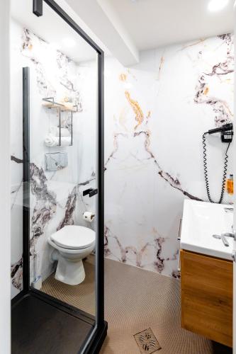 a bathroom with a shower with a toilet and a sink at Business Hotel Conference Center & Spa in Târgu-Mureş
