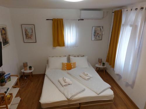 ein Schlafzimmer mit einem Bett mit zwei Kissen darauf in der Unterkunft Ljubovic apartman in Podgorica