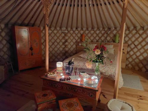 Zimmer mit einem Bett und einem Tisch in einer Jurte in der Unterkunft Yourte Bourgogne in Corvol-dʼEmbernard
