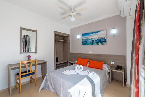 um quarto de hotel com duas camas e uma mesa em Hotel Costa Mediterraneo em El Arenal