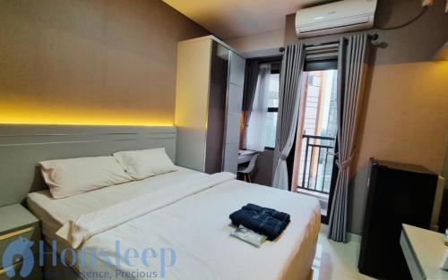 Tempat tidur dalam kamar di Apartemen Trans Park Cibubur by Housleep
