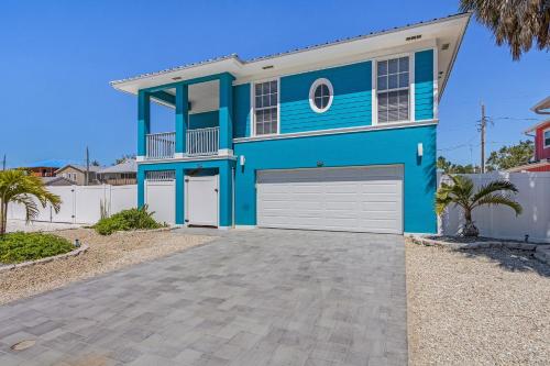 une maison bleue avec une allée devant elle dans l'établissement Inn-2-Blue - 155 Jefferson St home, à Fort Myers Beach