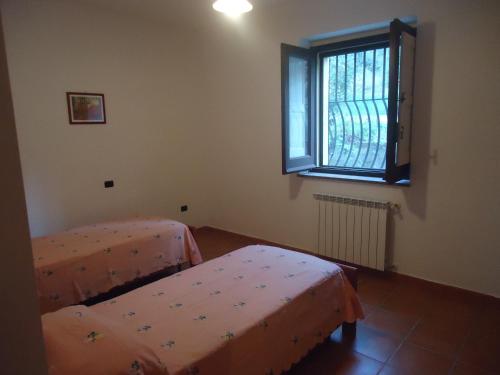 a bedroom with two beds and a window at Agriturismo Torre Rinusa in Pietrapaola