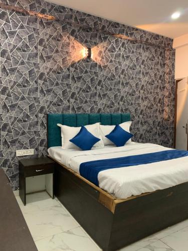 Hotel Paradise Inn في إندوري: غرفة نوم مع سرير ووسائد زرقاء