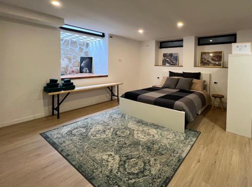 a bedroom with a bed and a desk and a window at La Perla in Monza