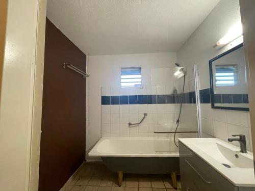 a bathroom with a bath tub and a sink at APPART SPA 20 MIN port croisière et aéroport in Sainte-Rose