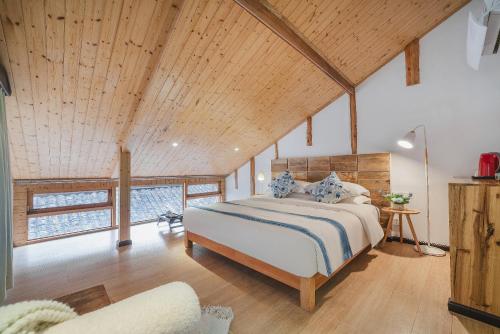 a bedroom with a bed in a room with wooden ceilings at 肇兴溪舍山堂 Creekside Inn in Liping