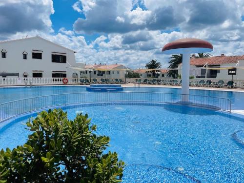 a large swimming pool in front of a resort at Apartamento Trini nuevo frente a la playa de Son Bou in Alaior