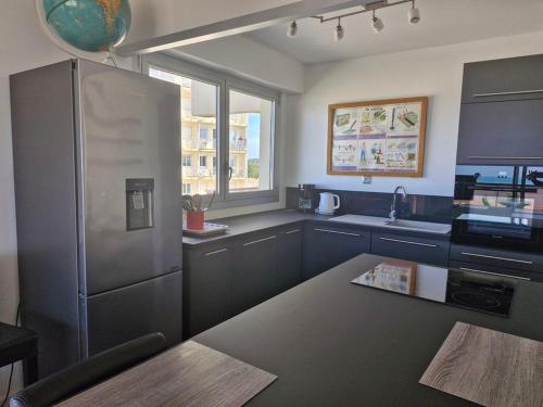 une cuisine avec un réfrigérateur en acier inoxydable et un évier dans l'établissement MAGNIFIQUE VUE SUR MER T3 rénové, à Saint-Jean-de-Monts