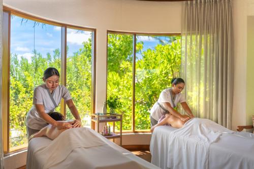 two women in a bedroom with two beds at OBLU SELECT Sangeli - Premium All Inclusive with Free Transfers in North Male Atoll