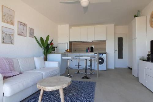 un salon avec un canapé blanc et une cuisine dans l'établissement Face à la Mer, à Port-la-Nouvelle