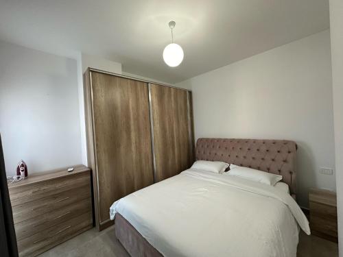 a bedroom with a large bed and a wooden cabinet at Mulaj Hotel in Tirana