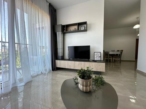 a living room with a table and a tv at Mulaj Hotel in Tirana