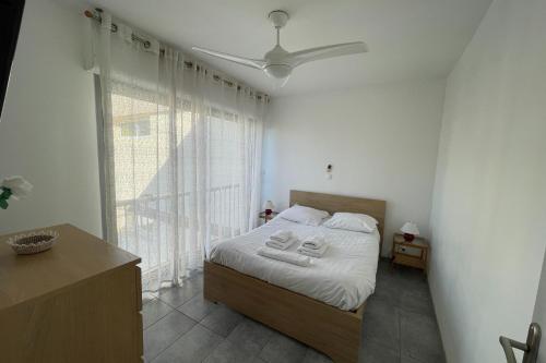 une chambre avec un lit et une grande fenêtre dans l'établissement Balaruc Les Bains Charmant T2, 2 pas des Thermes, à Balaruc-les-Bains