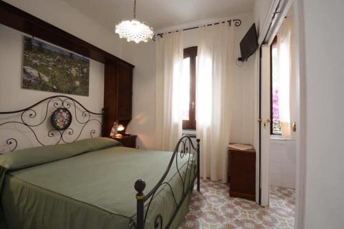 Un dormitorio con una cama verde y una lámpara de araña. en Il Paradiso Di Hyele, en Ascea