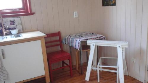 a kitchen with a table and a red chair and a table at Studio 33 in Arnhem