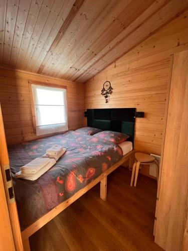 1 dormitorio con 1 cama en una cabaña de madera en Black Horse en Pasłęk