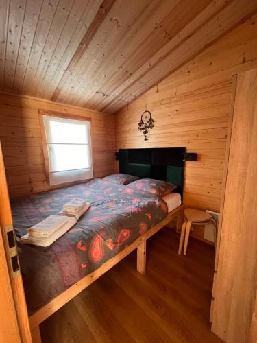 a bedroom with a bed in a wooden cabin at Black Horse in Pasłęk