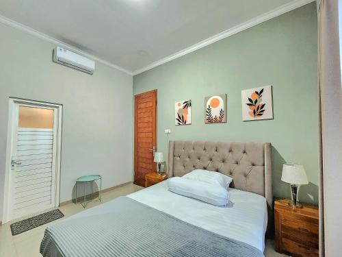 Schlafzimmer mit einem Bett mit Kopfteil und Wandmalereien in der Unterkunft Villa Di Batu in Batu
