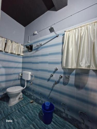 a bathroom with a toilet and a shower at Faith Dorms in Siliguri