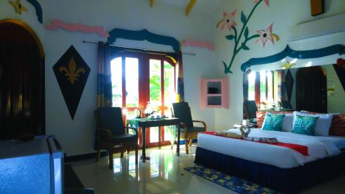 a living room with a bed and a table in it at MG Chateau Resort in El Nido