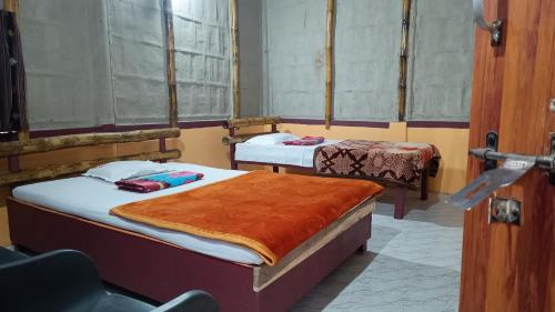 a room with two beds in a room at Jyoti Home Bamboo Garden Lodge in Majuli