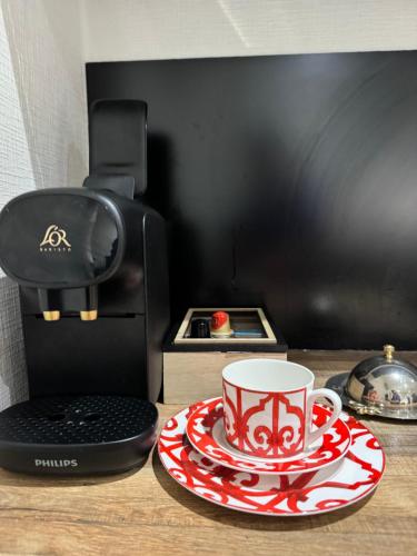 a coffee maker and a cup on a table at Maison Colombage normande in Flers