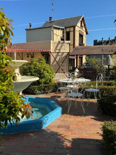 a patio with a table and chairs and a pool at Maison Colombage normande in Flers