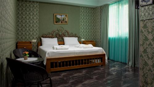 Schlafzimmer mit einem Bett und einem Tisch mit Stühlen in der Unterkunft West Star Hotel in Kutaissi