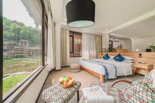 a hotel room with a bed and a window at 肇兴溪舍山堂 Creekside Inn in Liping