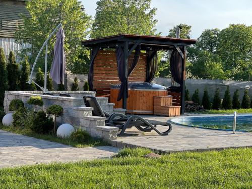 a swimming pool with a gazebo next to a pool at Black Horse in Pasłęk