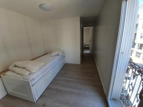 a small bedroom with a bed and a balcony at Triplex avec terrasse en rooftop, au coeur de Sete in Sète
