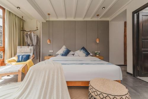 a bedroom with a large bed and a chair at 肇兴溪舍山堂 Creekside Inn in Liping