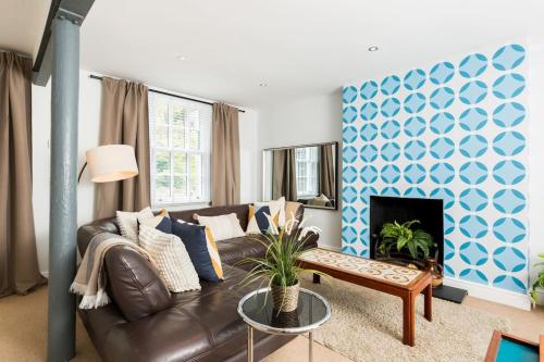 a living room with a couch and a fireplace at Fabulous Malvern Townhouse in Great Malvern