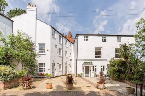 an exterior view of a white house with potted plants at Fabulous Malvern Townhouse in Great Malvern