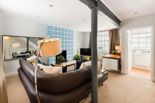 a living room with a brown leather couch in a room at Fabulous Malvern Townhouse in Great Malvern