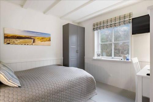 - une chambre blanche avec un lit et une fenêtre dans l'établissement Holiday Apartment With Ocean View, à Hals