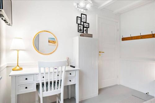 - un bureau blanc dans une chambre blanche avec un miroir dans l'établissement Holiday Apartment With Ocean View, à Hals