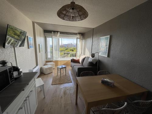un salon avec un canapé et une table dans l'établissement Sete, Studio en bord de mer, vue imprenable, à Sète