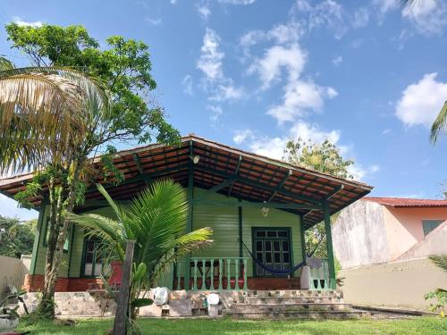 uma casa verde com telhado castanho em Casa Condomínio de luxo em Ananindeua