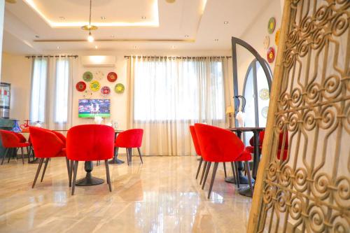a dining room with red chairs and a table at نزل قايا Hôtel Gaïa in Nabeul