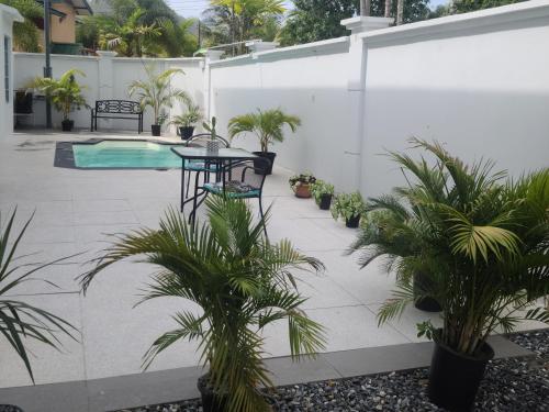 a patio with plants and a table and a pool at Riverside Apartments Bed and Breakfast in San Juan