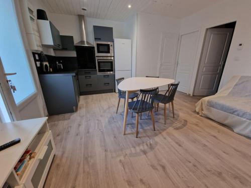 une pièce avec une table et des chaises et une chambre dans l'établissement Superbe appartement rénové à neuf centre bourg, à Brem-sur-Mer