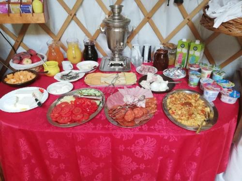 una mesa con platos de comida en un mantel rosa en Mennyország Jurta Hotel 