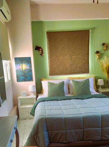 a bedroom with a bed with a green wall at Amalia's Maisonette in Marathos