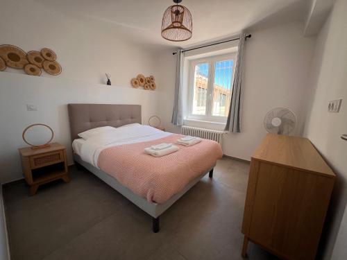 une chambre avec un lit et une fenêtre dans l'établissement Provence deux chambres & jardin, à Antibes