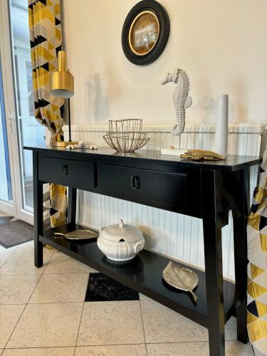une console noire avec un plateau en verre dans l'établissement Villa ÉOLE - À 200 mètres de la plage, à Bray-Dunes