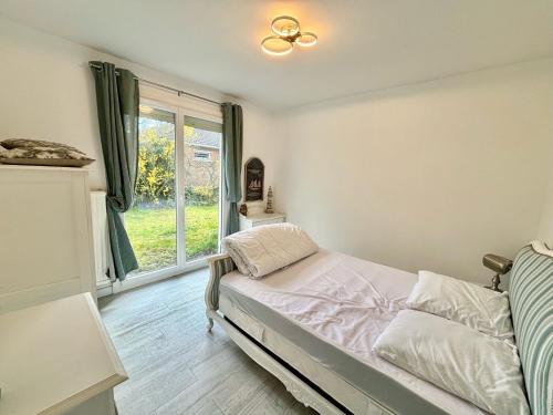 una camera da letto con un letto e una finestra di Villa ÉOLE - À 200 mètres de la plage a Bray-Dunes