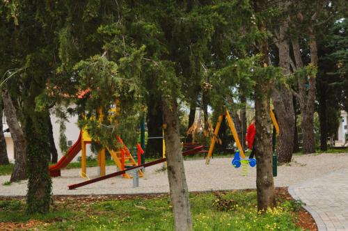 un parco giochi con altalene colorate in un parco di Apartments Milica a Malinska